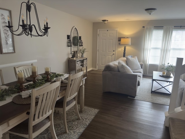 dining room with a chandelier, dark wood finished floors, and baseboards