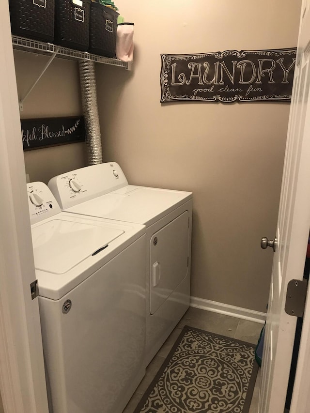 laundry room with tile patterned flooring, laundry area, washer and clothes dryer, and baseboards