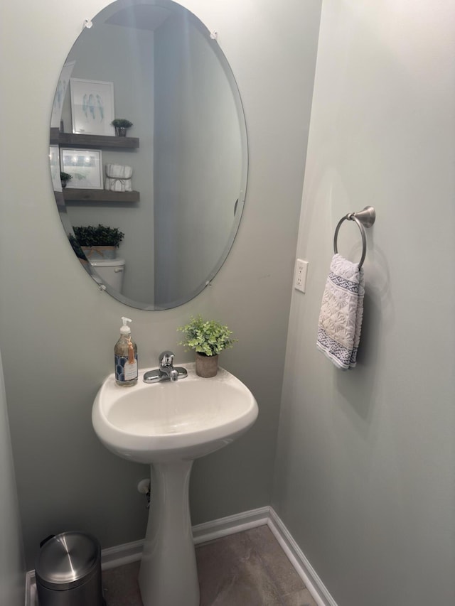 bathroom with a sink and baseboards