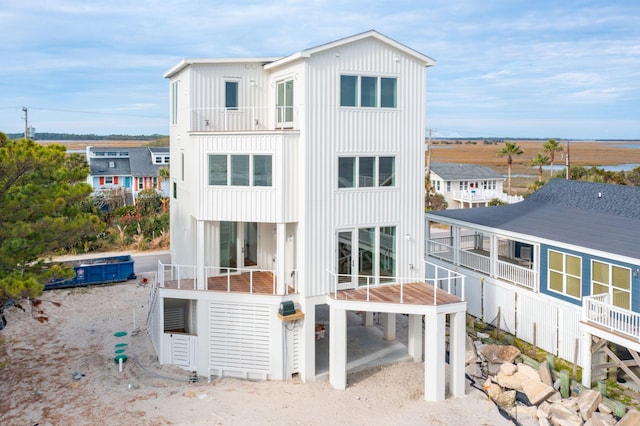 back of property with board and batten siding and a balcony