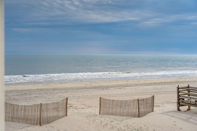 water view featuring a view of the beach and fence