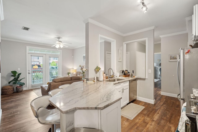 kitchen with a ceiling fan, dark wood finished floors, light stone countertops, and stainless steel appliances
