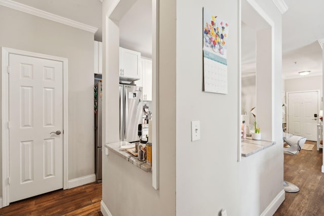 hall with baseboards, ornamental molding, and dark wood-style flooring