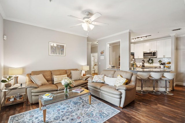 living room with visible vents, ornamental molding, dark wood-style floors, rail lighting, and a ceiling fan