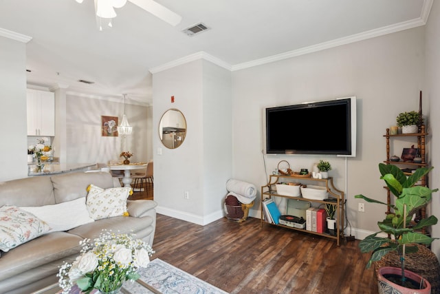 living area with ceiling fan, visible vents, wood finished floors, baseboards, and ornamental molding