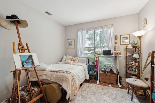 bedroom with visible vents and wood finished floors