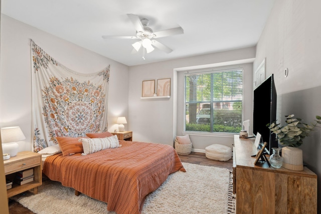 bedroom featuring baseboards, a ceiling fan, and wood finished floors