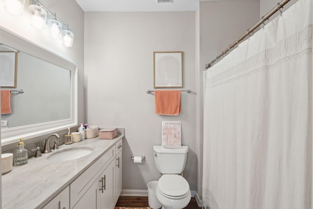 full bath with vanity, baseboards, and toilet