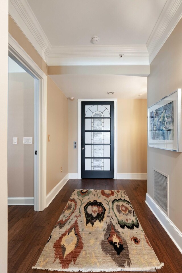 foyer entrance with crown molding, dark wood finished floors, and baseboards