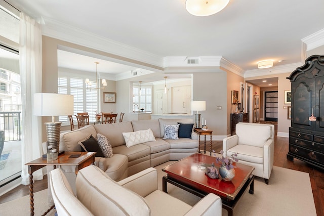 living room with wood finished floors, crown molding, and baseboards