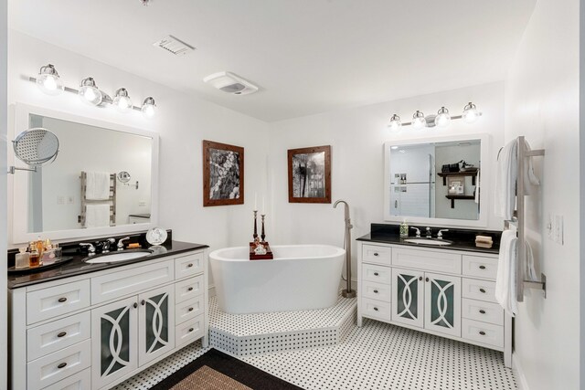bathroom featuring a freestanding tub and two vanities