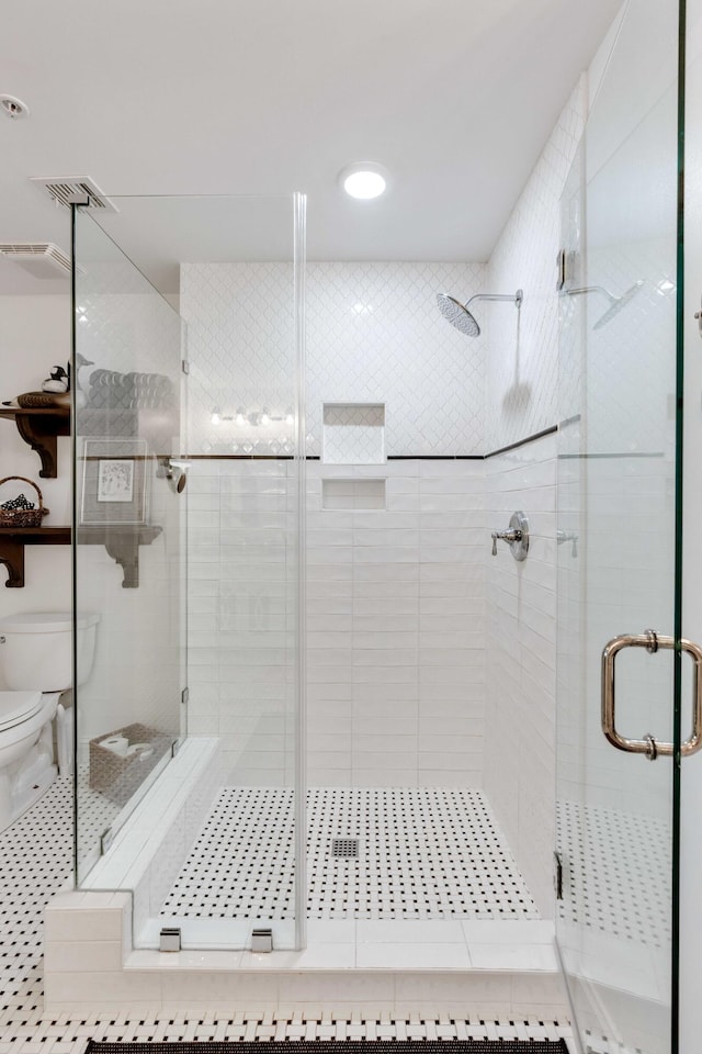 full bath with toilet, a shower stall, and tile patterned floors