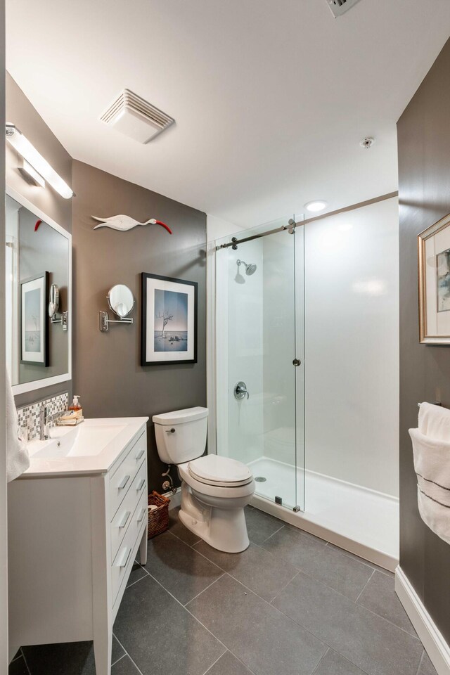 full bathroom with a shower stall, toilet, vanity, and tile patterned floors