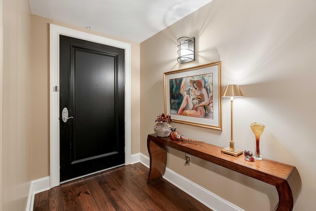 entrance foyer with dark wood-style flooring and baseboards
