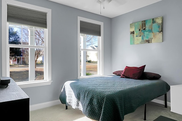 carpeted bedroom with multiple windows and ceiling fan