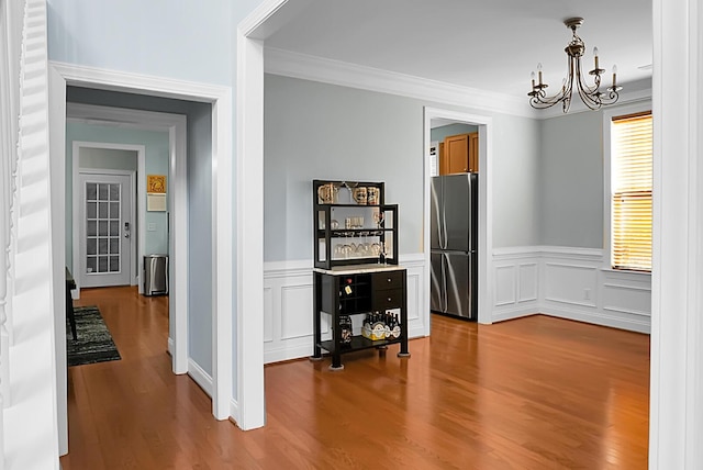 dining room featuring hardwood / wood-style flooring, a notable chandelier, and crown molding