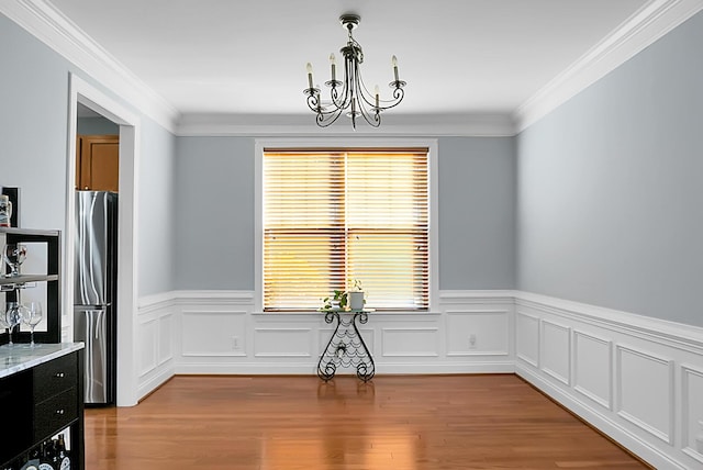 dining space with crown molding, a healthy amount of sunlight, and a notable chandelier