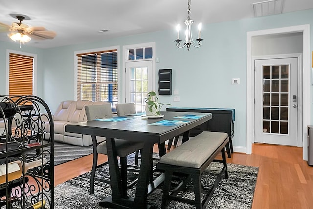 dining room with ceiling fan with notable chandelier and hardwood / wood-style flooring