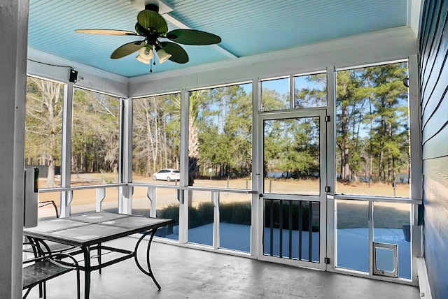 unfurnished sunroom featuring ceiling fan and a healthy amount of sunlight