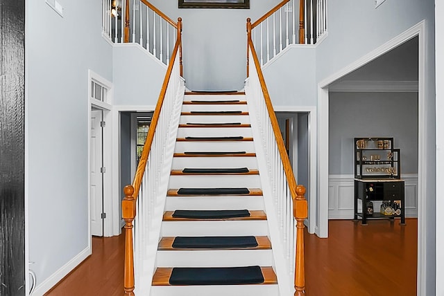 stairway featuring hardwood / wood-style floors and ornamental molding