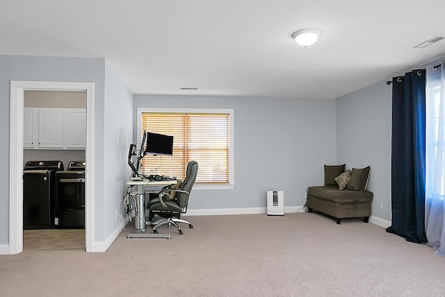 carpeted home office with washing machine and clothes dryer