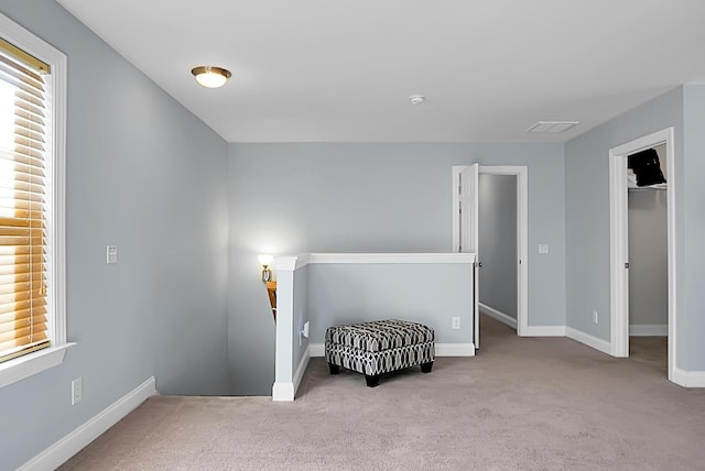 sitting room featuring light carpet and plenty of natural light