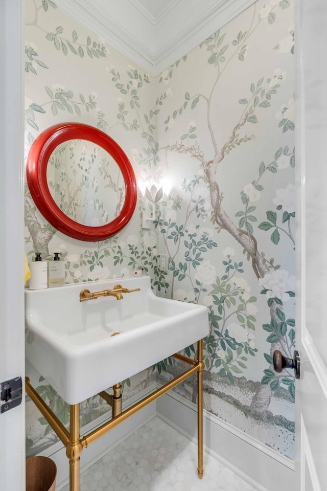 bathroom with wallpapered walls, ornamental molding, and a sink