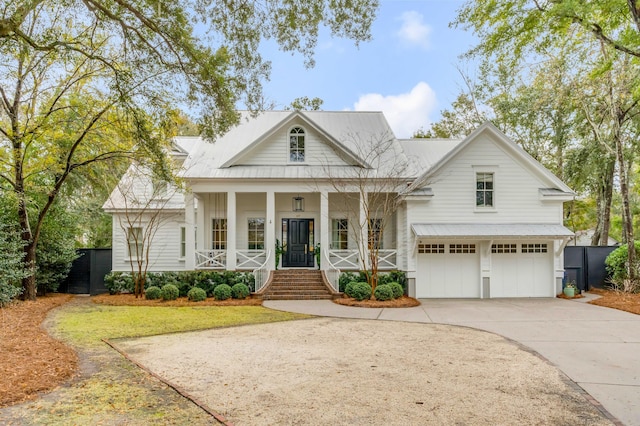 neoclassical home featuring a garage, concrete driveway, a porch, metal roof, and a front lawn