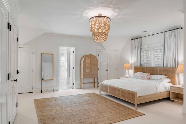 bedroom with light carpet, ensuite bath, visible vents, and a notable chandelier