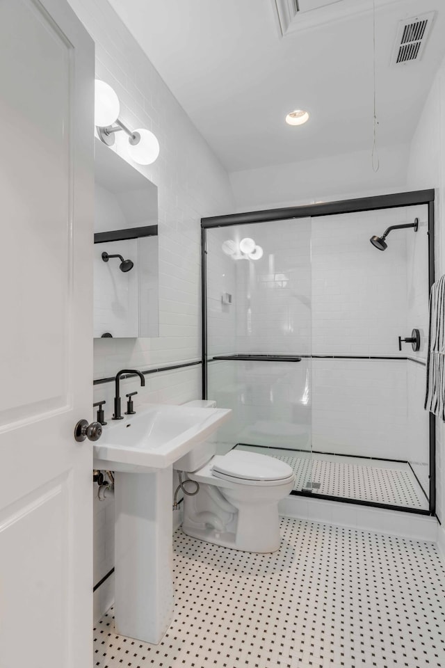 full bathroom with visible vents, toilet, tile walls, and a shower stall