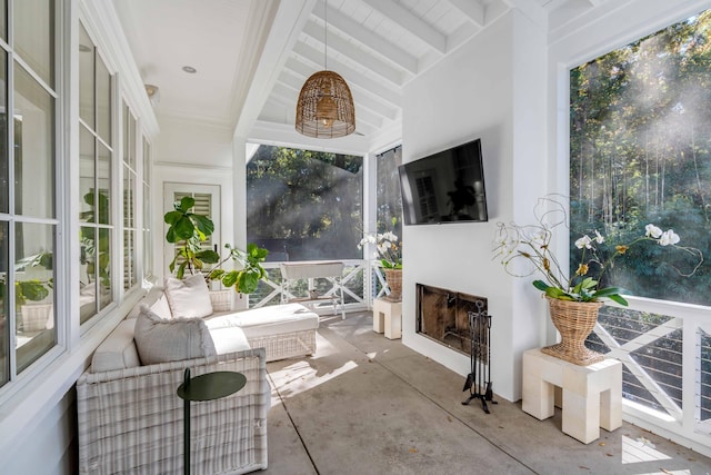 sunroom featuring a fireplace and beamed ceiling