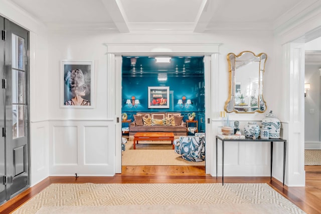 hallway with beamed ceiling, wood finished floors, and a decorative wall