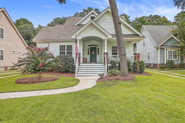 view of front of property featuring covered porch and a front lawn