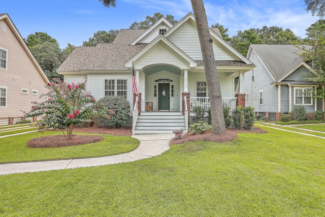 view of front of property featuring covered porch and a front lawn