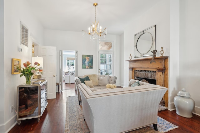 living room with dark hardwood / wood-style flooring and a notable chandelier