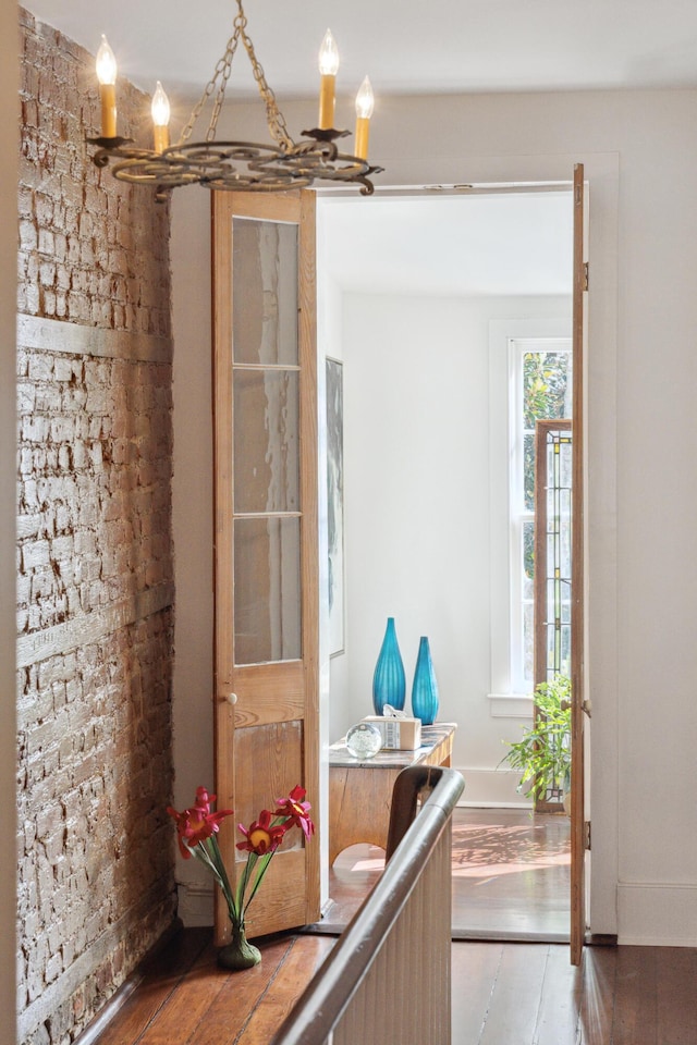 doorway with hardwood / wood-style flooring and an inviting chandelier