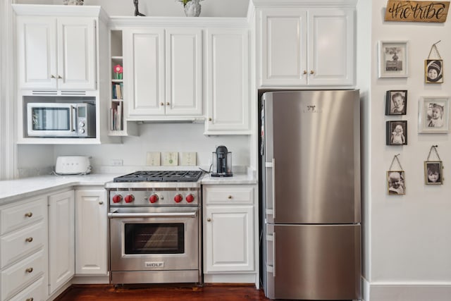 kitchen featuring light stone countertops, white cabinetry, and stainless steel appliances