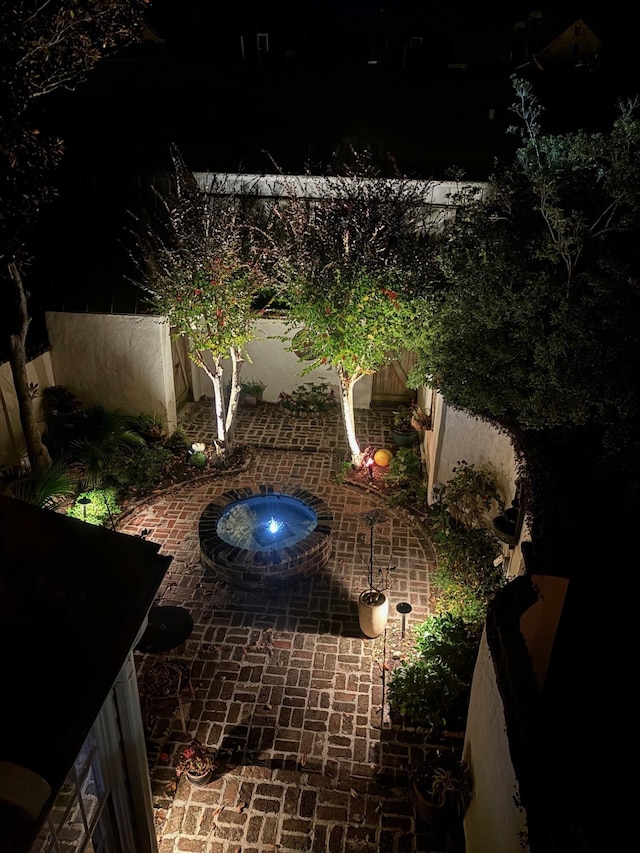 patio at twilight featuring a hot tub