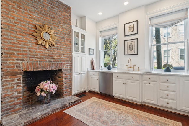 bar featuring dark hardwood / wood-style flooring, dishwasher, and white cabinets