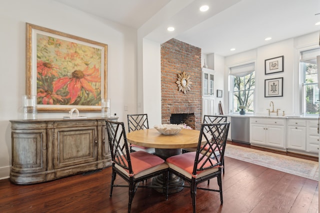 dining room featuring a fireplace, dark hardwood / wood-style floors, and sink