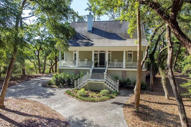 3052 Seabrook Island Rd, Seabrook Island, SC 29455 - view of front facade featuring covered porch, roof with shingles, a chimney, stairs, and concrete driveway