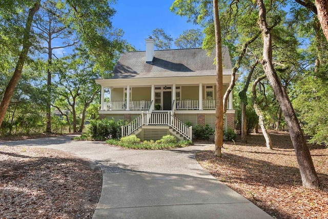 3052 Seabrook Island Rd, Seabrook Island, SC 29455 - coastal inspired home featuring covered porch, driveway, stairs, and a chimney