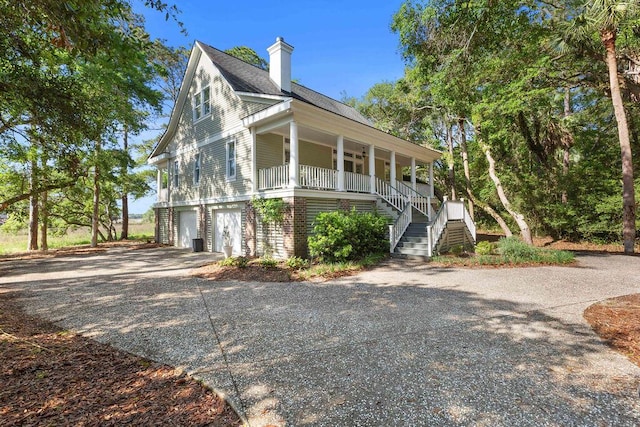 3052 Seabrook Island Rd, Seabrook Island, SC 29455 - view of side of home featuring covered porch, stairway, an attached garage, driveway, and a chimney