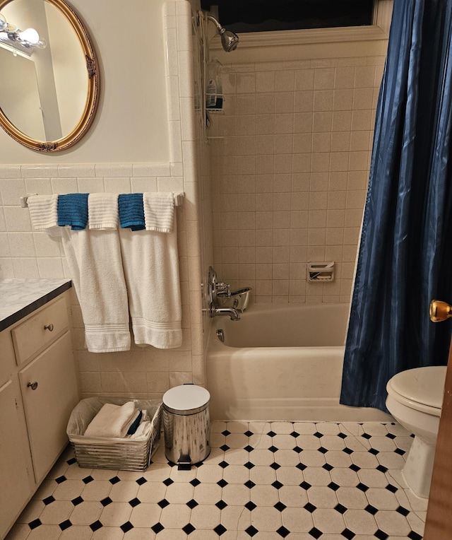 full bathroom with vanity, shower / bath combination with curtain, toilet, and tile walls