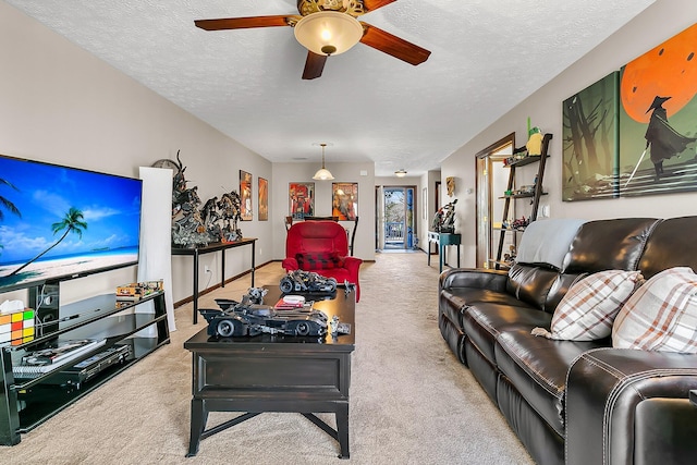 carpeted living room featuring a ceiling fan and a textured ceiling