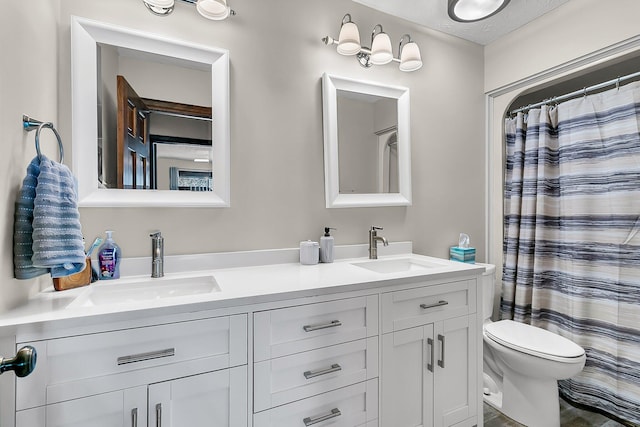 full bathroom with double vanity, a shower with shower curtain, a sink, and toilet