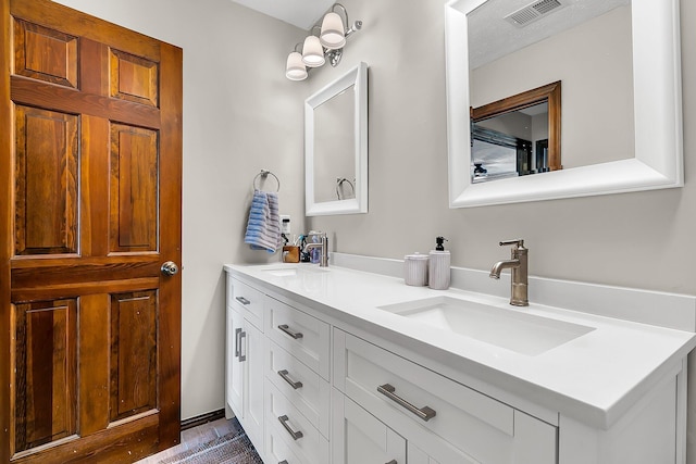 full bathroom featuring double vanity, visible vents, and a sink