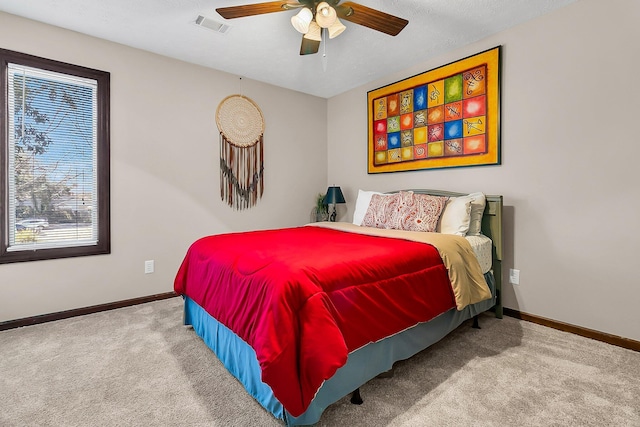 carpeted bedroom with baseboards, visible vents, and ceiling fan