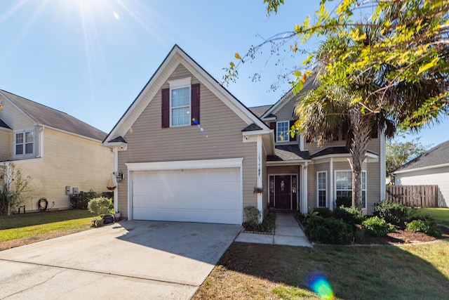 view of property featuring a garage and a front lawn