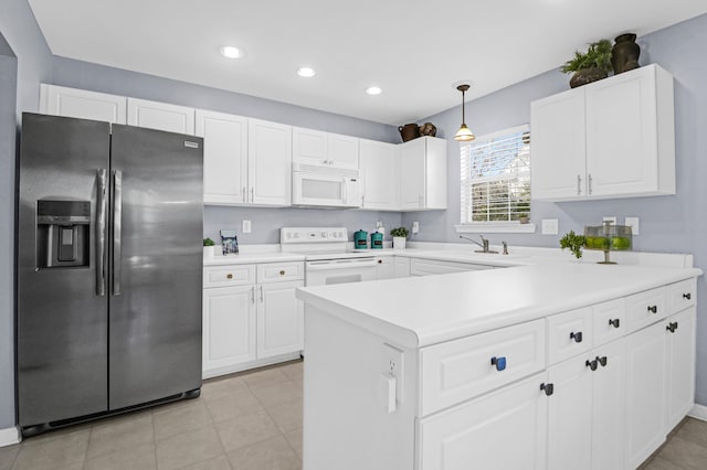 kitchen featuring hanging light fixtures, white cabinets, sink, and white appliances